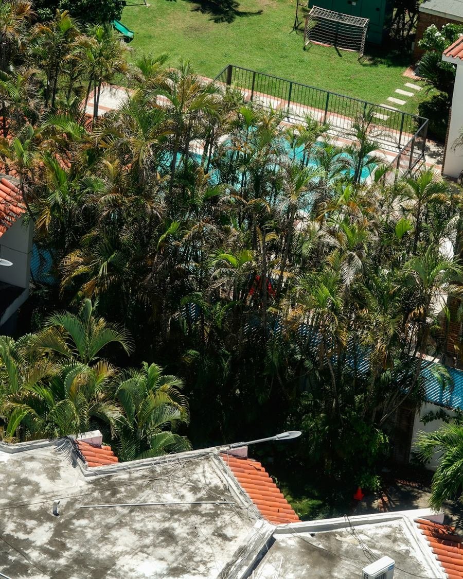 Telhado de telha cerâmica de uma moradia com chaminé de tijolo, sob céu azul limpo.