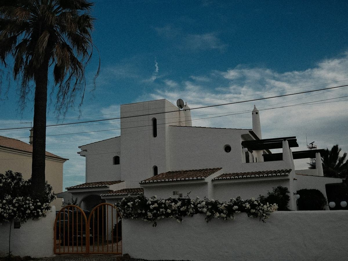Moradia moderna de paredes brancas com palmeira sob céu azul
