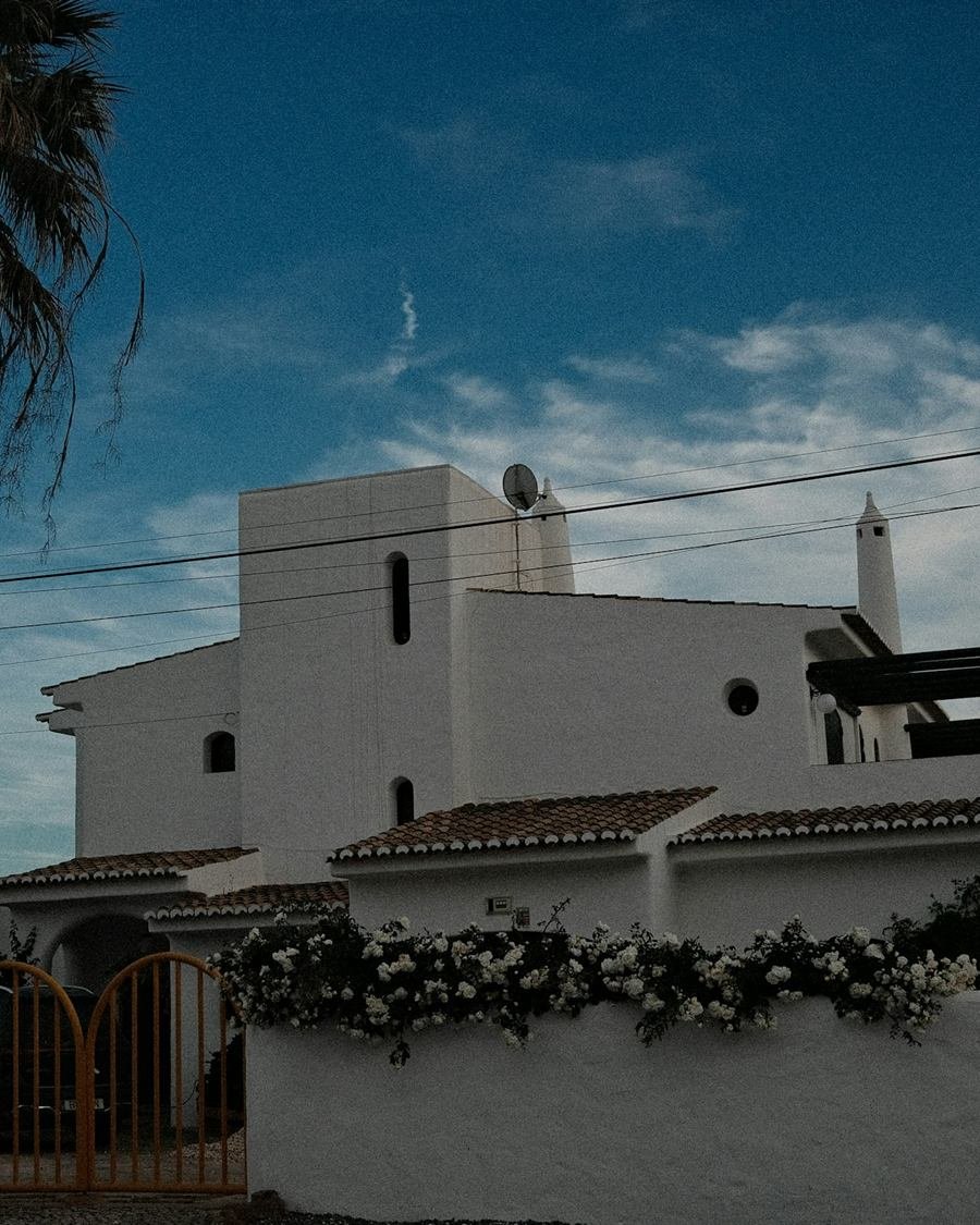 Moradia moderna de paredes brancas com palmeira sob céu azul