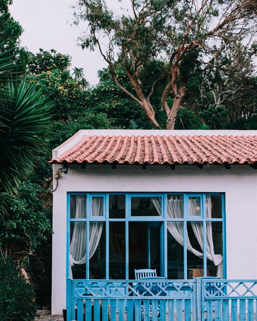Casa tradicional portuguesa de paredes brancas, barras azuis e telhado de telha